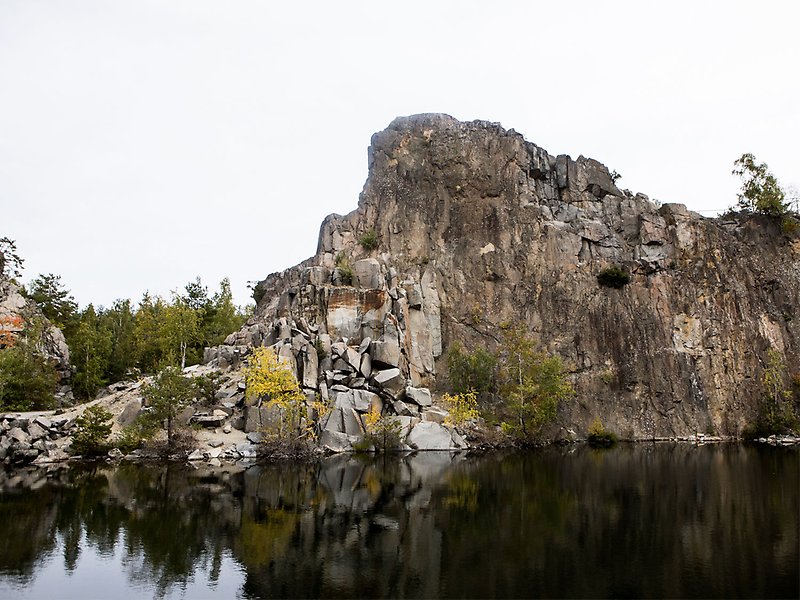 Stenhuggarebyn. Bild på stenhuggarberg. Framför berget finns en sjö.